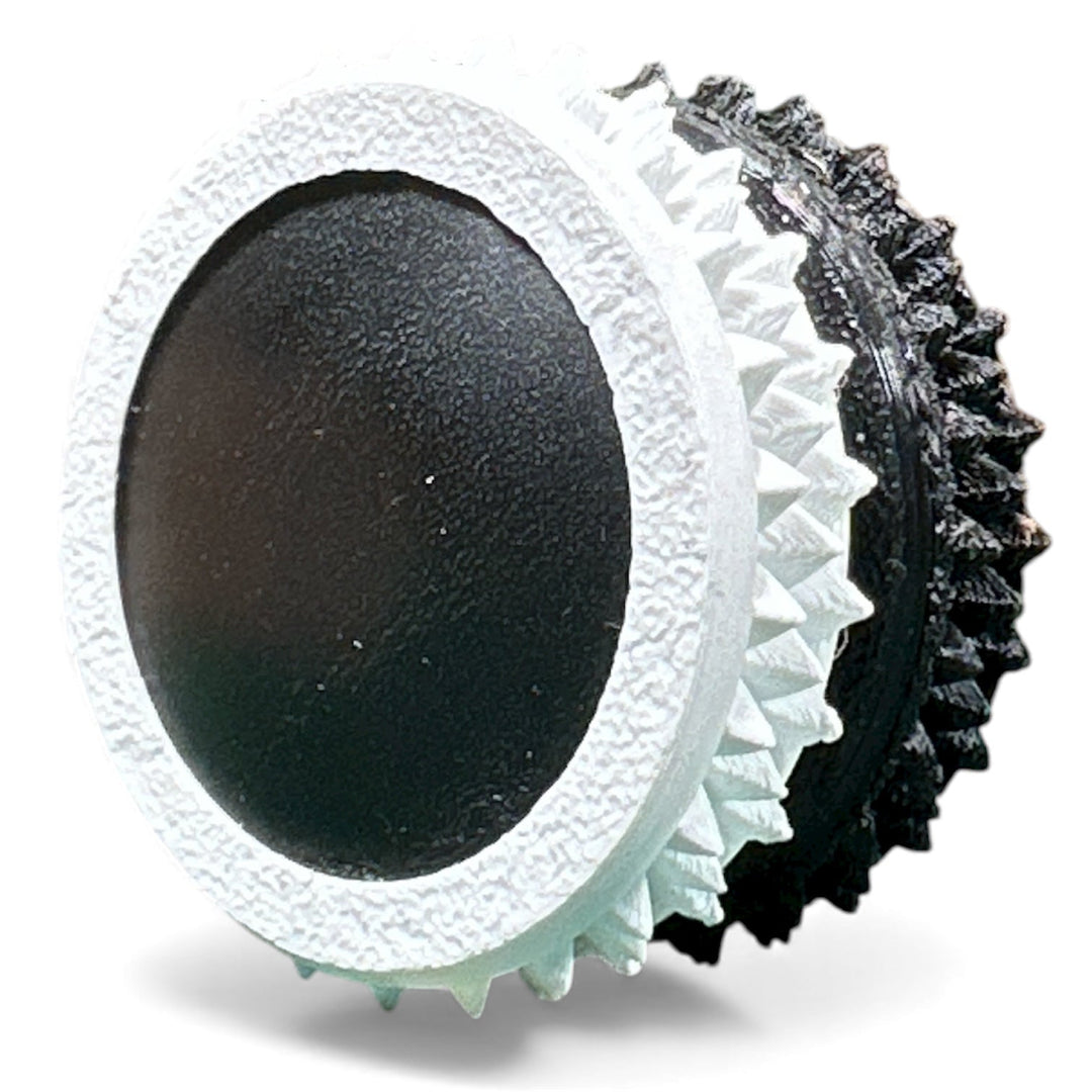 White fidget moon toy with black oval center and spiky ridged edges