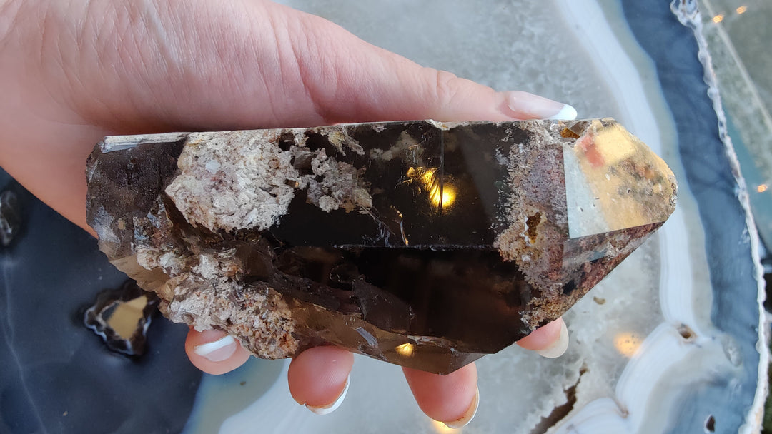 Smoky quartz point cluster with dark brown facets and jagged crystal edges