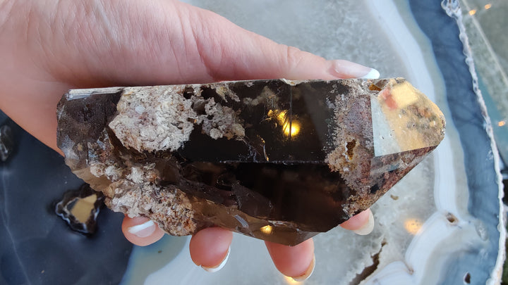 Smoky quartz point cluster with dark brown facets and jagged crystal edges