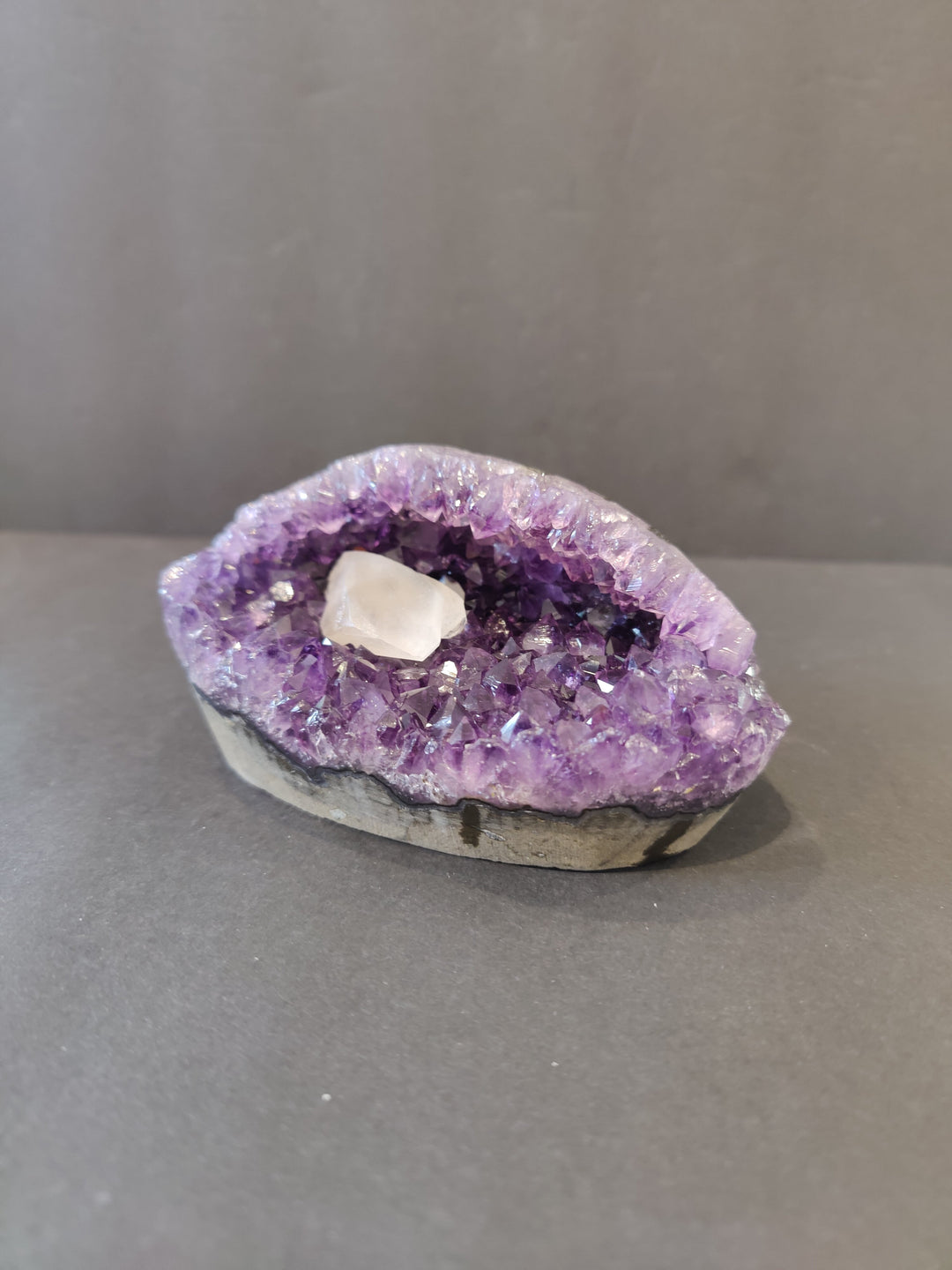 Amethyst geode sculpture with purple crystal cavity and white calcite center