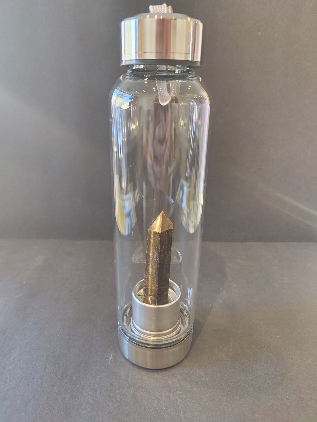 Crystal-infused glass water bottle with stainless steel cap and gold-toned crystal insert