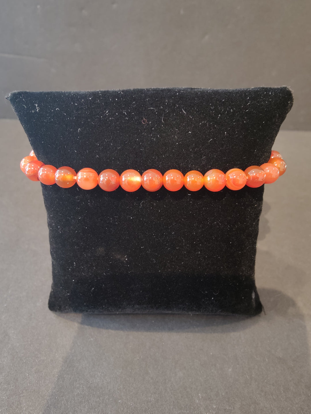 Beaded stone bracelet with 6mm orange round beads and stretch cord.