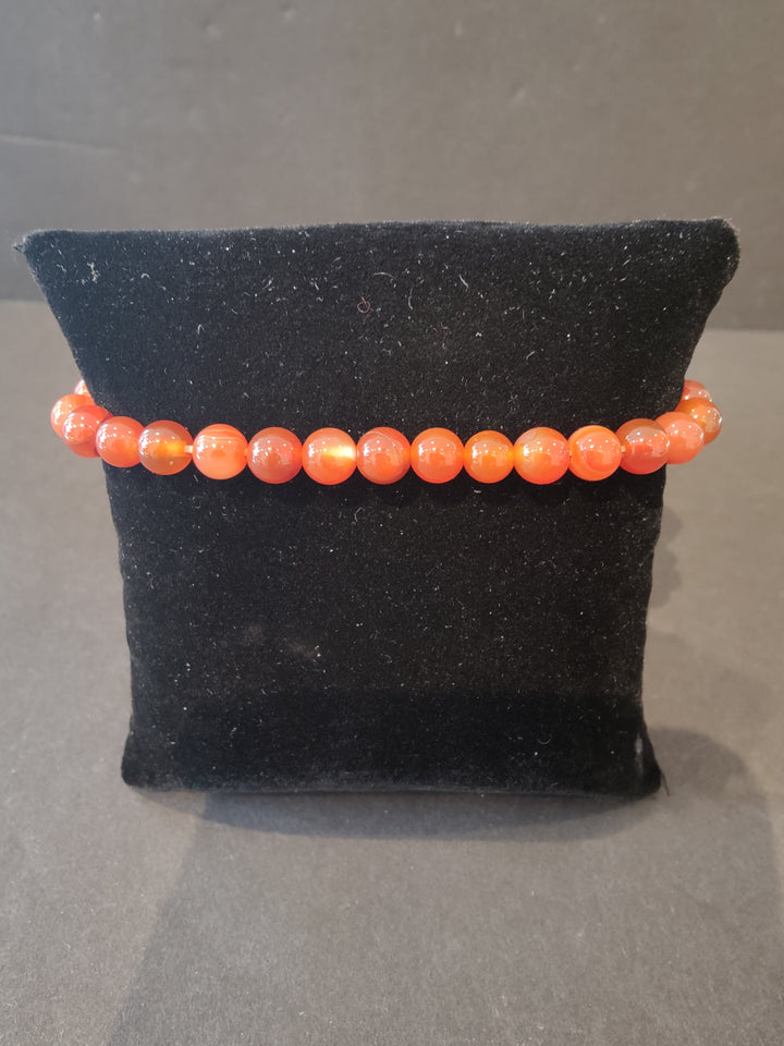 Beaded stone bracelet with 6mm orange round beads and stretch cord.