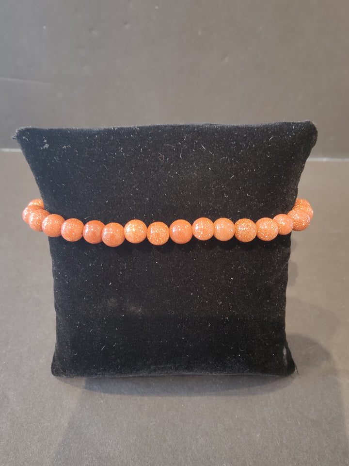 Beaded stone bracelet with 6mm orange and pinkish round beads.