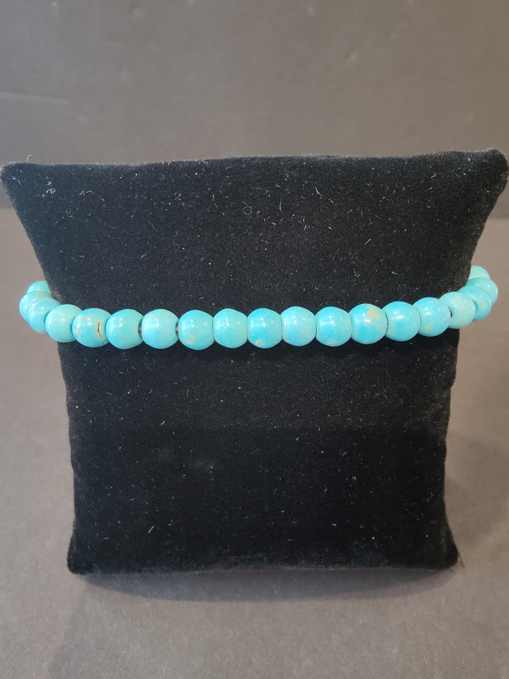 Beaded stone bracelet with 6mm light blue round beads and stretch cord.