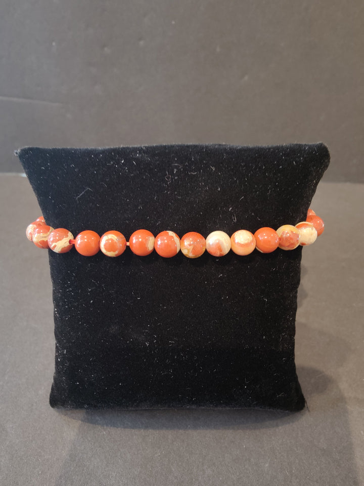 Beaded stone bracelet with 6mm orange and peach round beads and stretch cord.