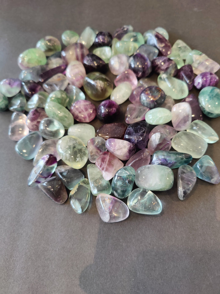 Assorted tumbled fluorite stones in rainbow colors, mixed shapes and sizes