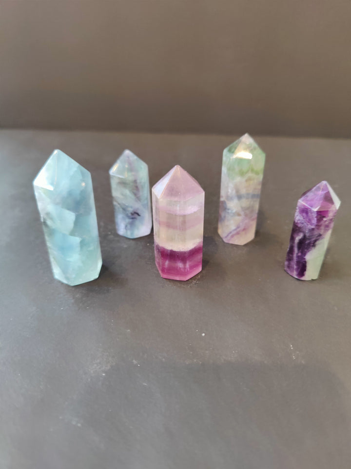 Assorted multi-color fluorite points, faceted obelisk shapes with banded blue, pink, and purple tones