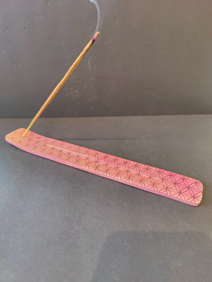Pink wood incense burner with geometric print, long flat tray holding incense