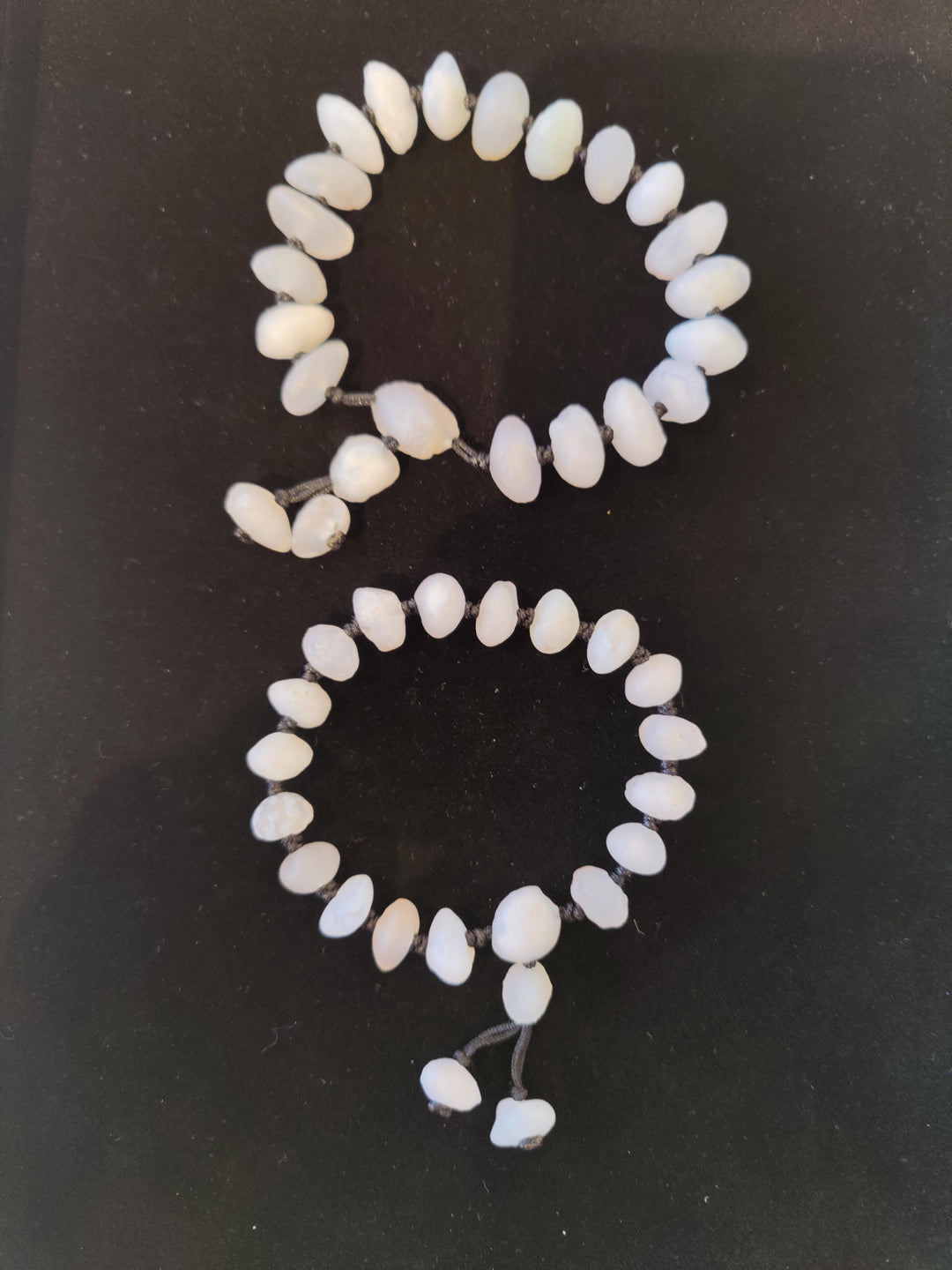 White beaded agate bracelet with smooth oval beads and short dangle charm