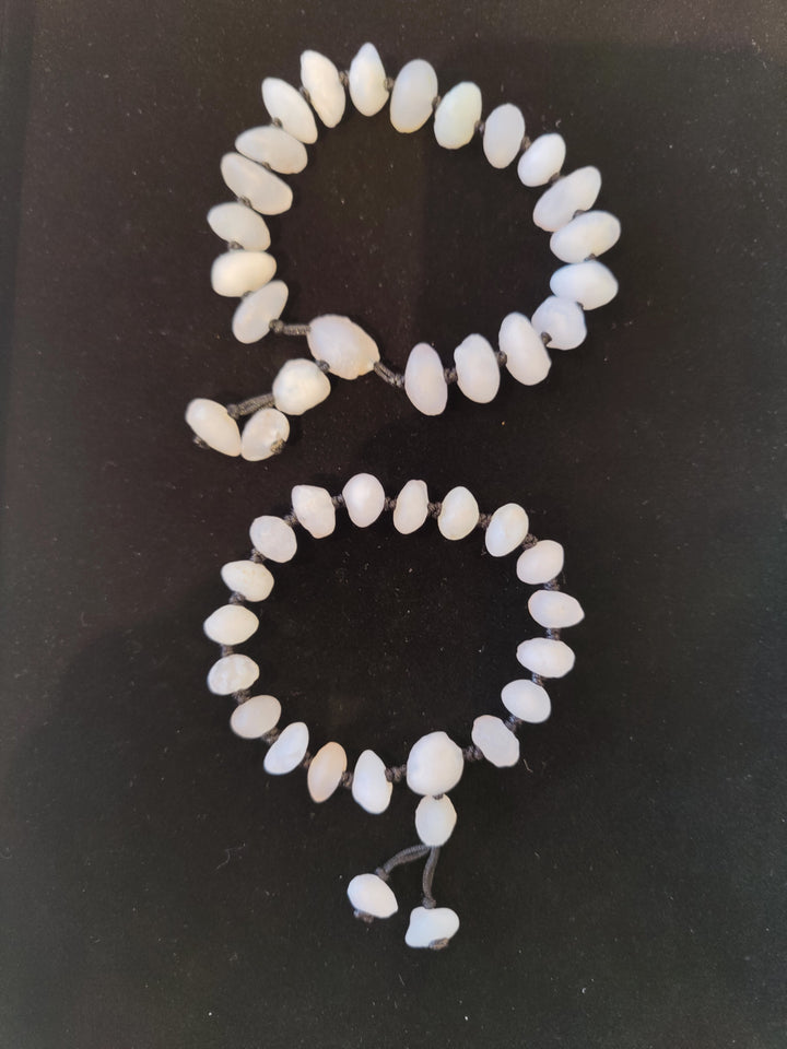 White beaded agate bracelet with smooth oval beads and short dangle charm