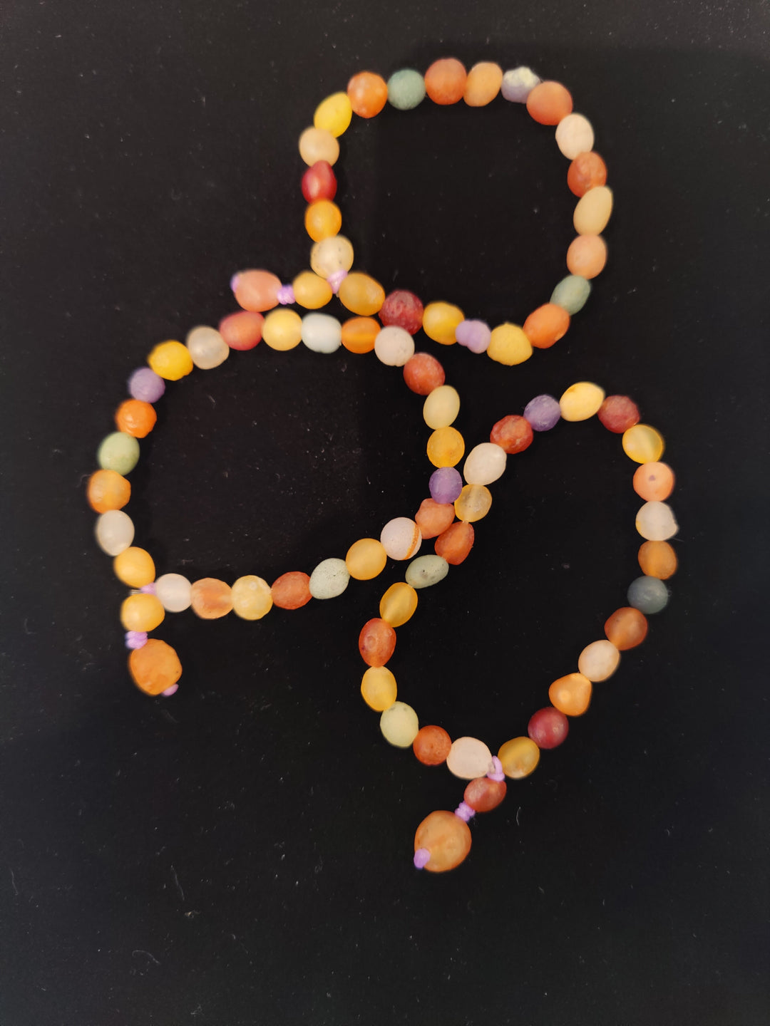 Multicolor beaded agate bracelet with round beads in orange, green, and purple
