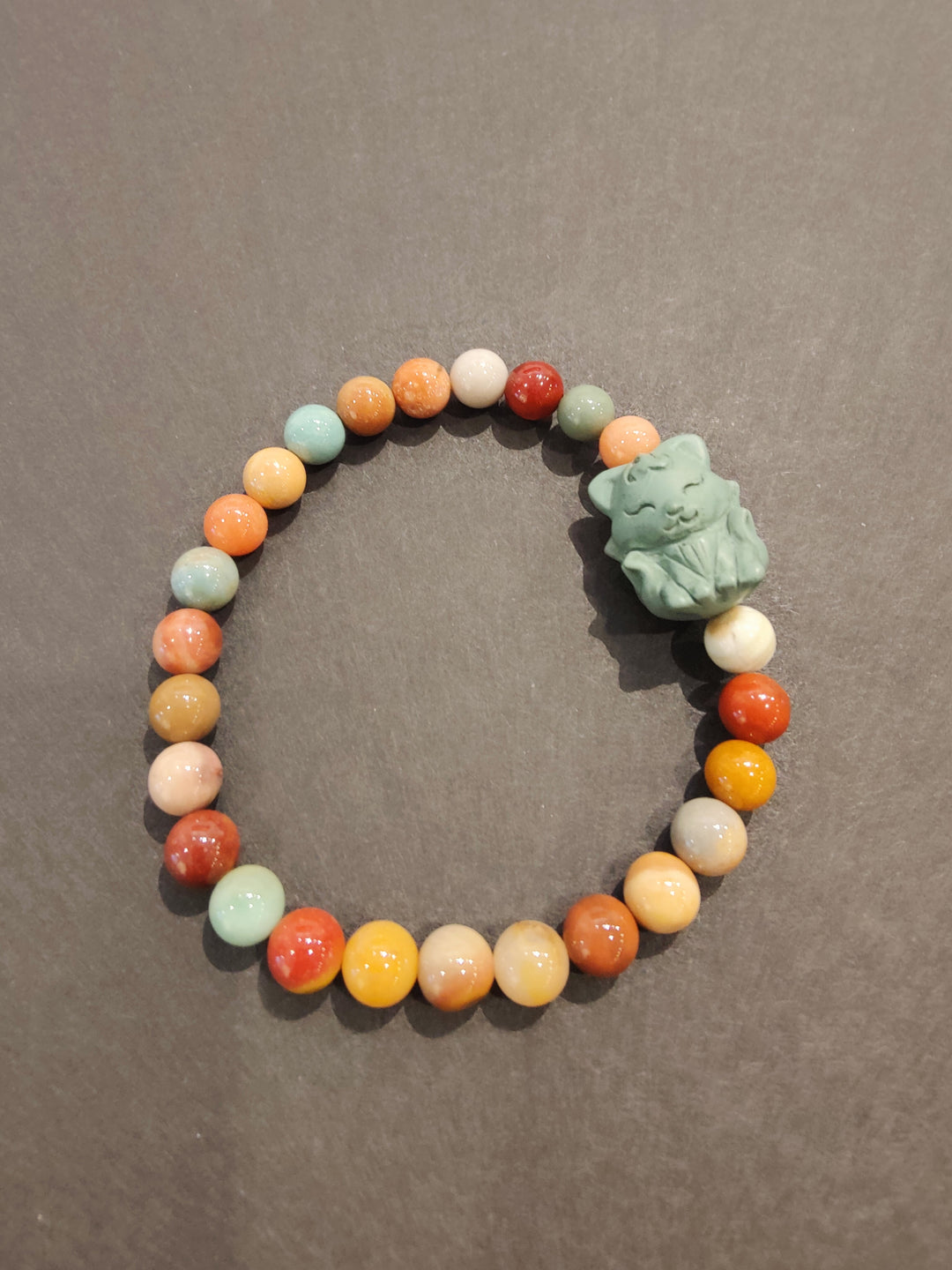Multi-color bead bracelet with green animal face charm