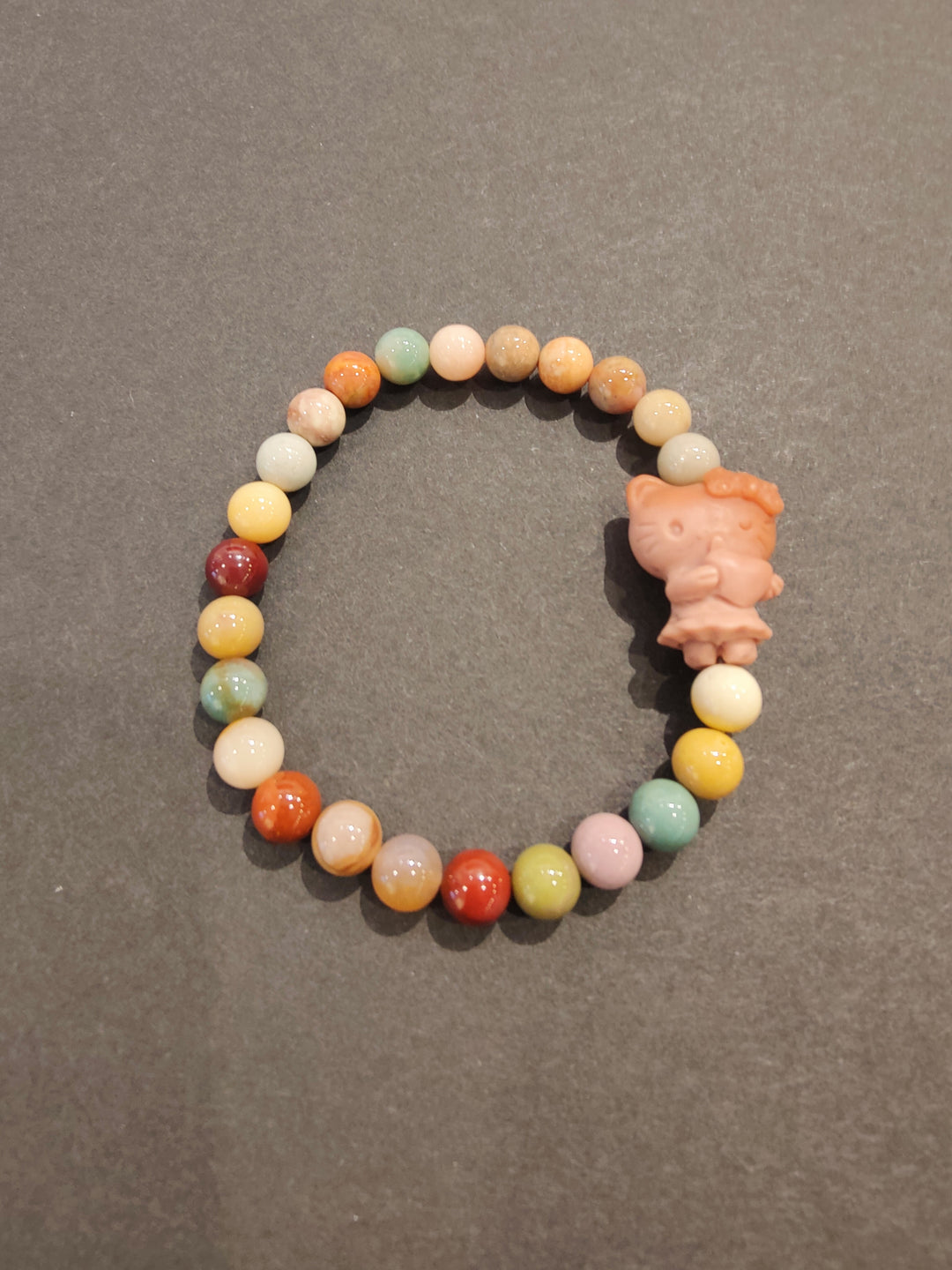 Multi-color bead bracelet with pink animal figurine charm