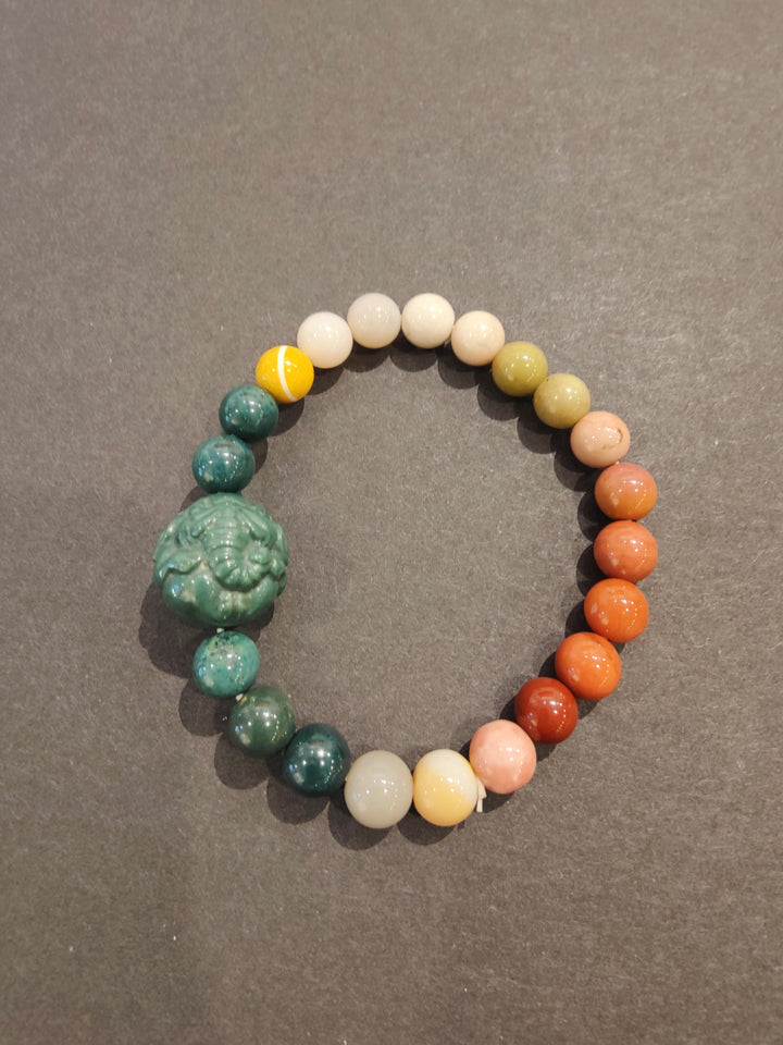 Multi-color bead bracelet with textured green animal charm