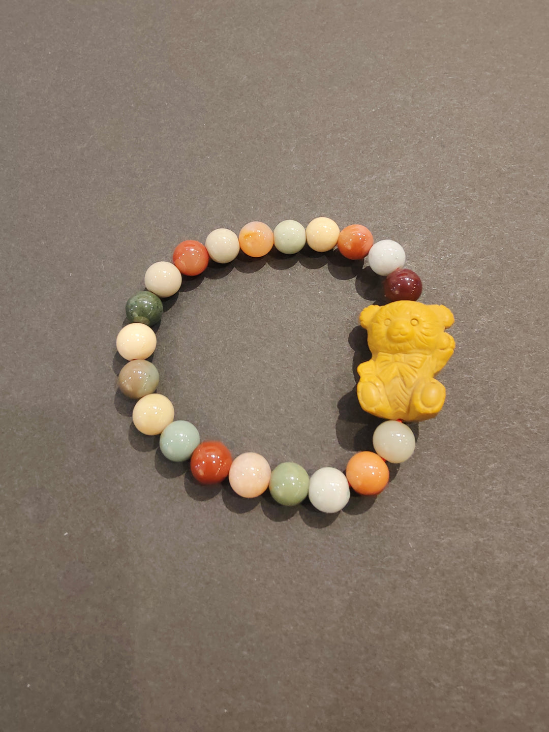 Multi-color bead bracelet with yellow animal face charm