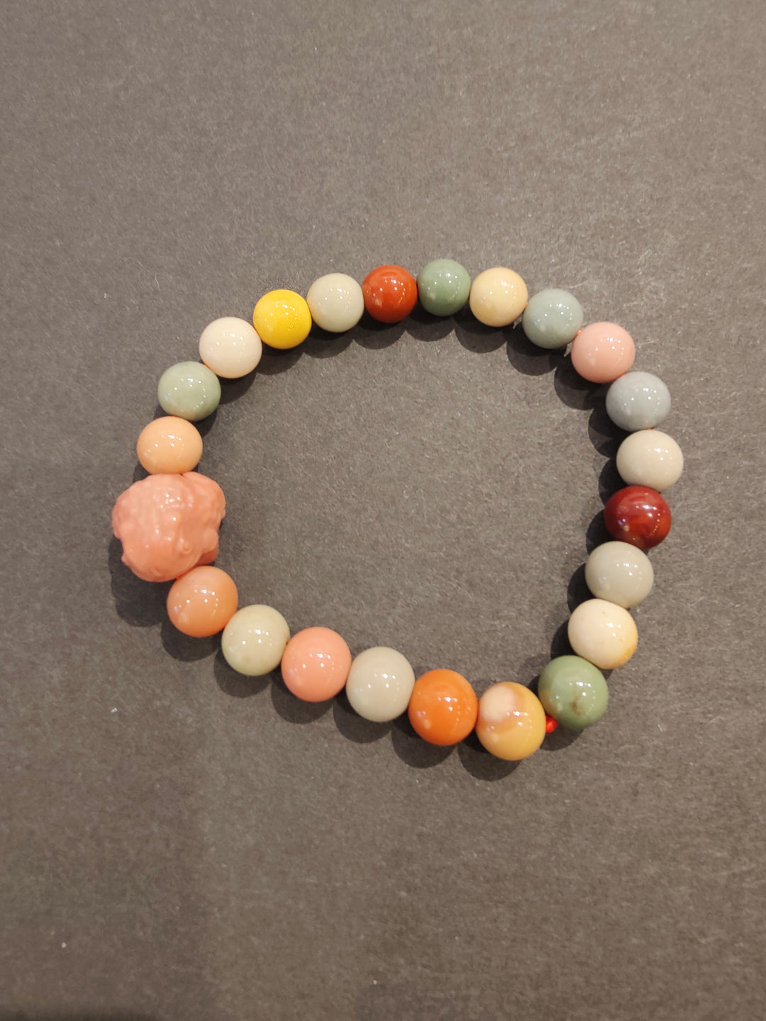 Multi-color bead bracelet with peach animal figurine charm
