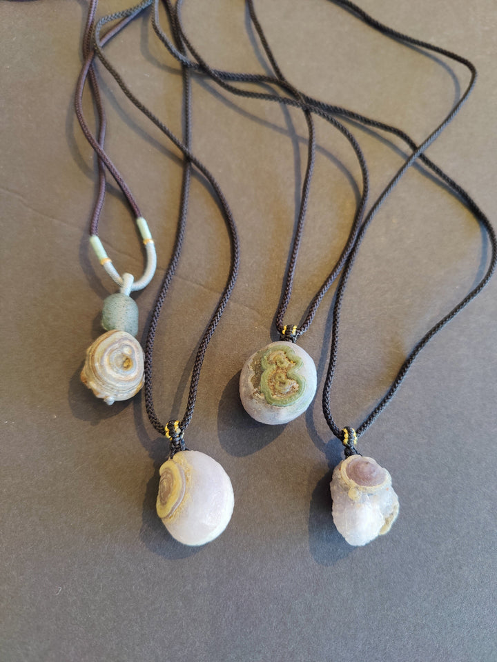 Eye agate pendant necklace with white-and-gold cabochon on dark cord