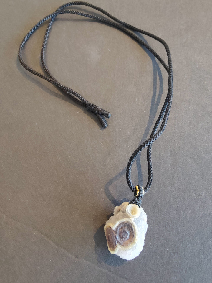 Eye agate pendant necklace with round purple-and-white stone on dark cord