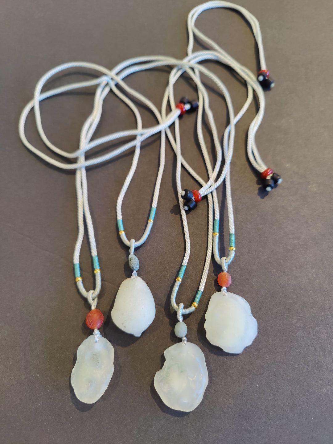 Adjustable cord necklace with translucent teardrop stone pendants and bead accents