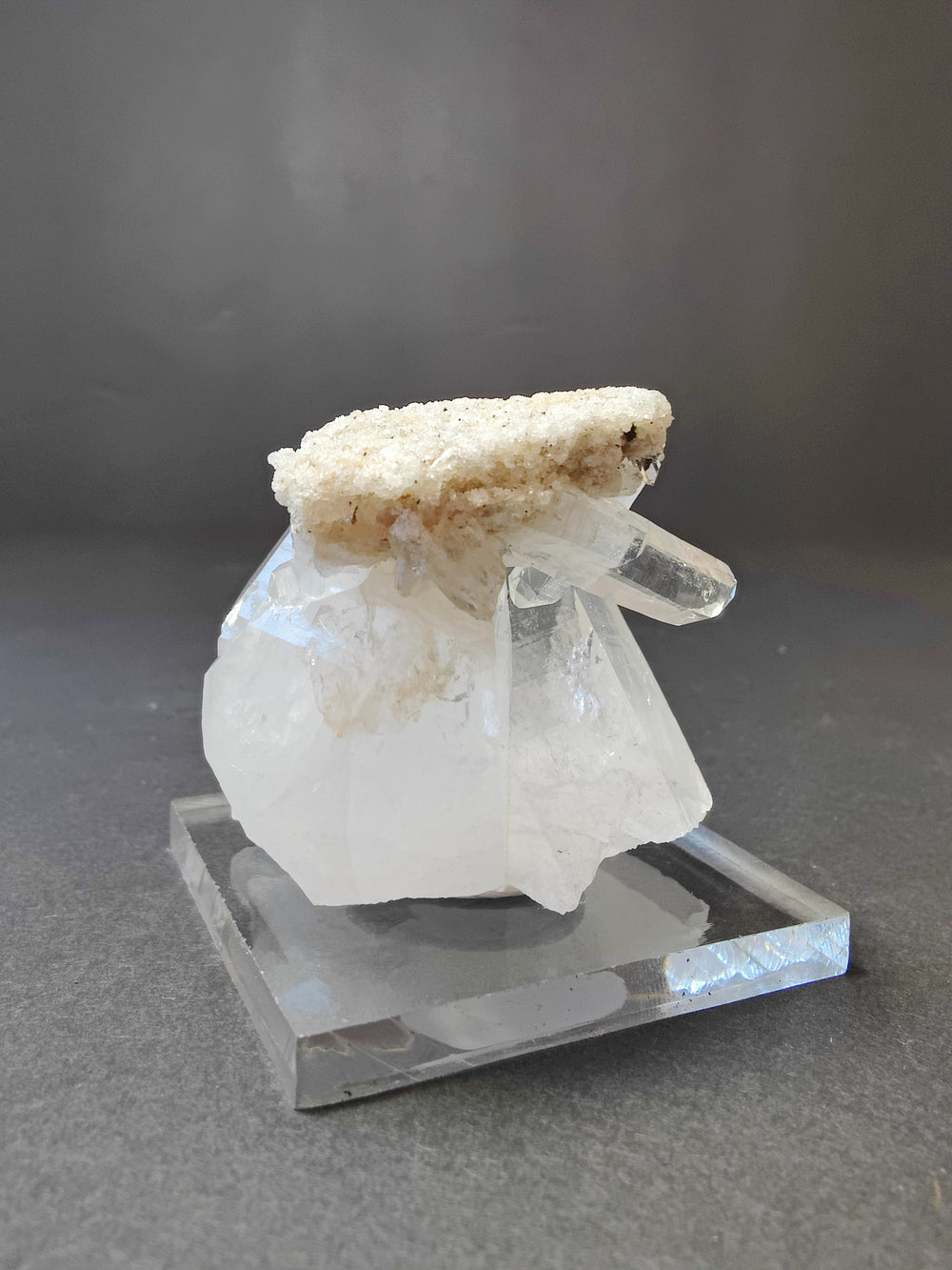 Quartz crystal cluster on clear base; white points with tan mineral rough top