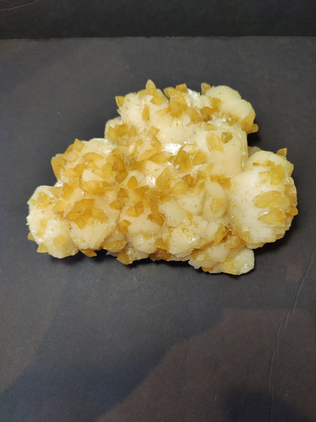 Golden calcite crystal cluster with yellow translucent crystals on pale matrix