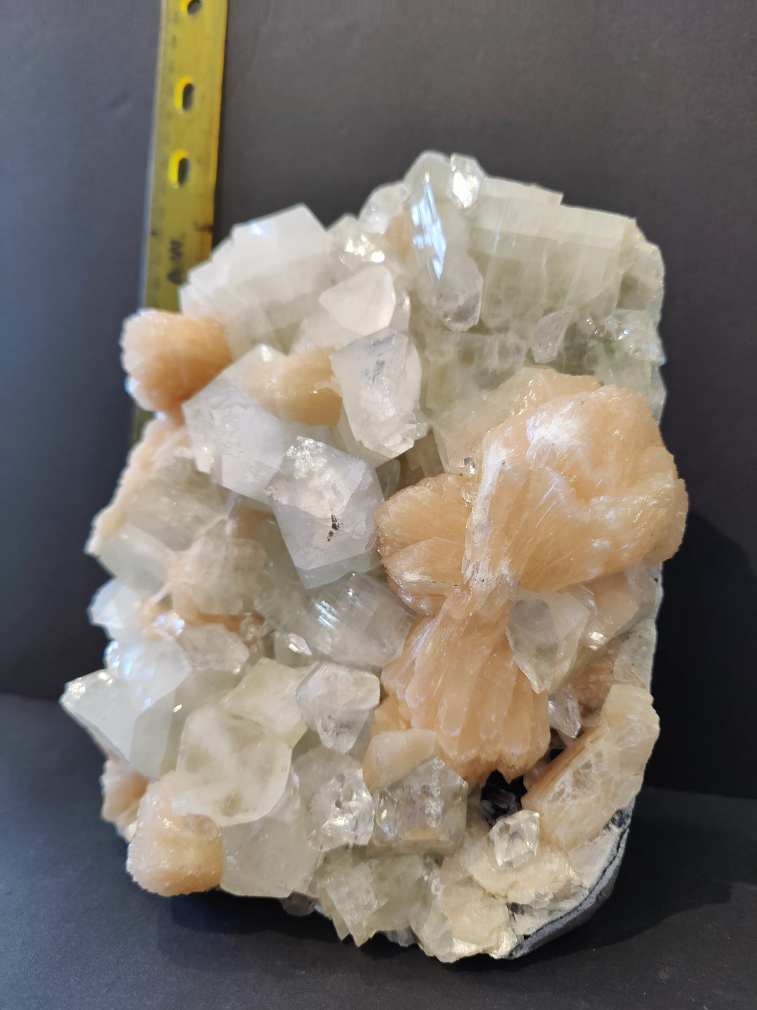 Apophyllite mineral specimen with white and peach crystals, angled view