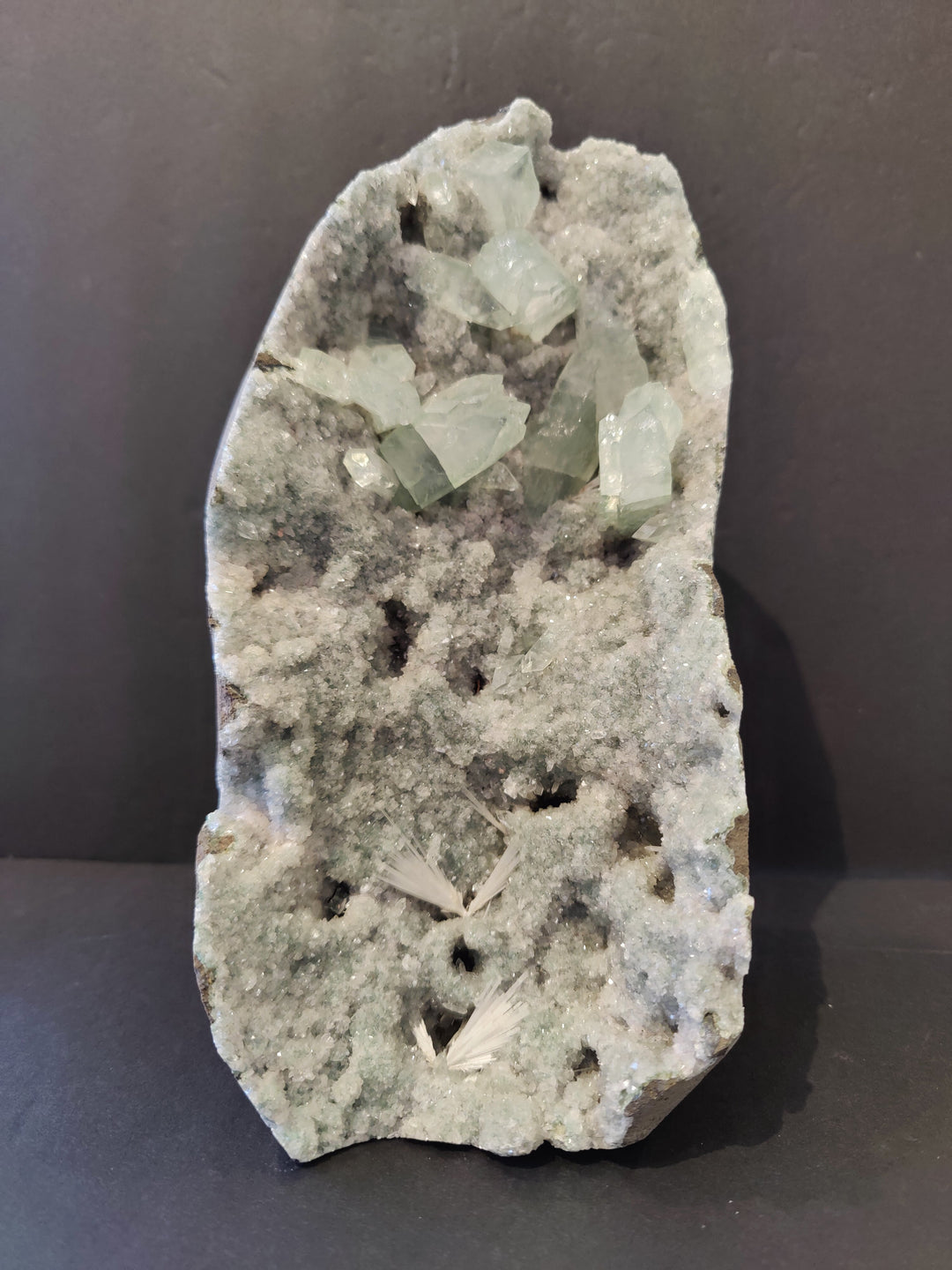 Apophyllite crystal specimen with light green crystals on gray rock matrix