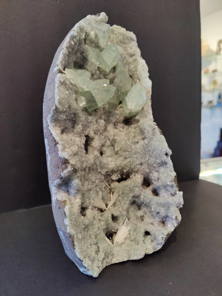 Apophyllite crystal specimen featuring light green translucent crystals in gray rock
