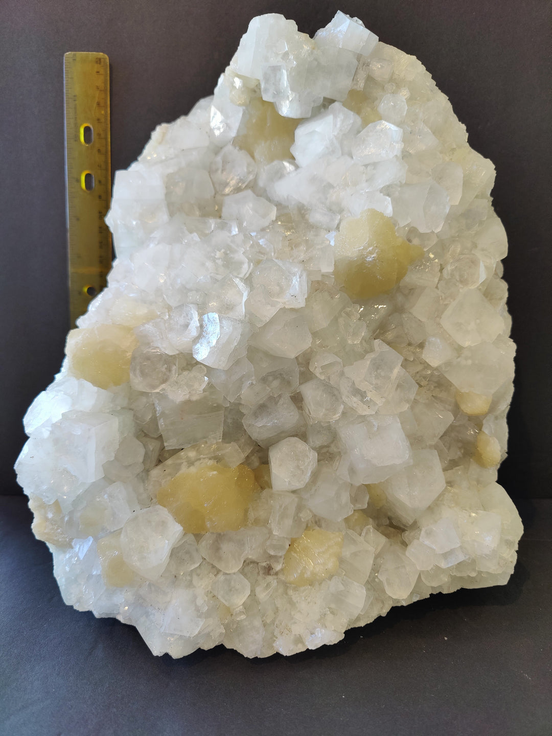 Apophyllite and stilbite crystal cluster with scale ruler; white and pale yellow crystals