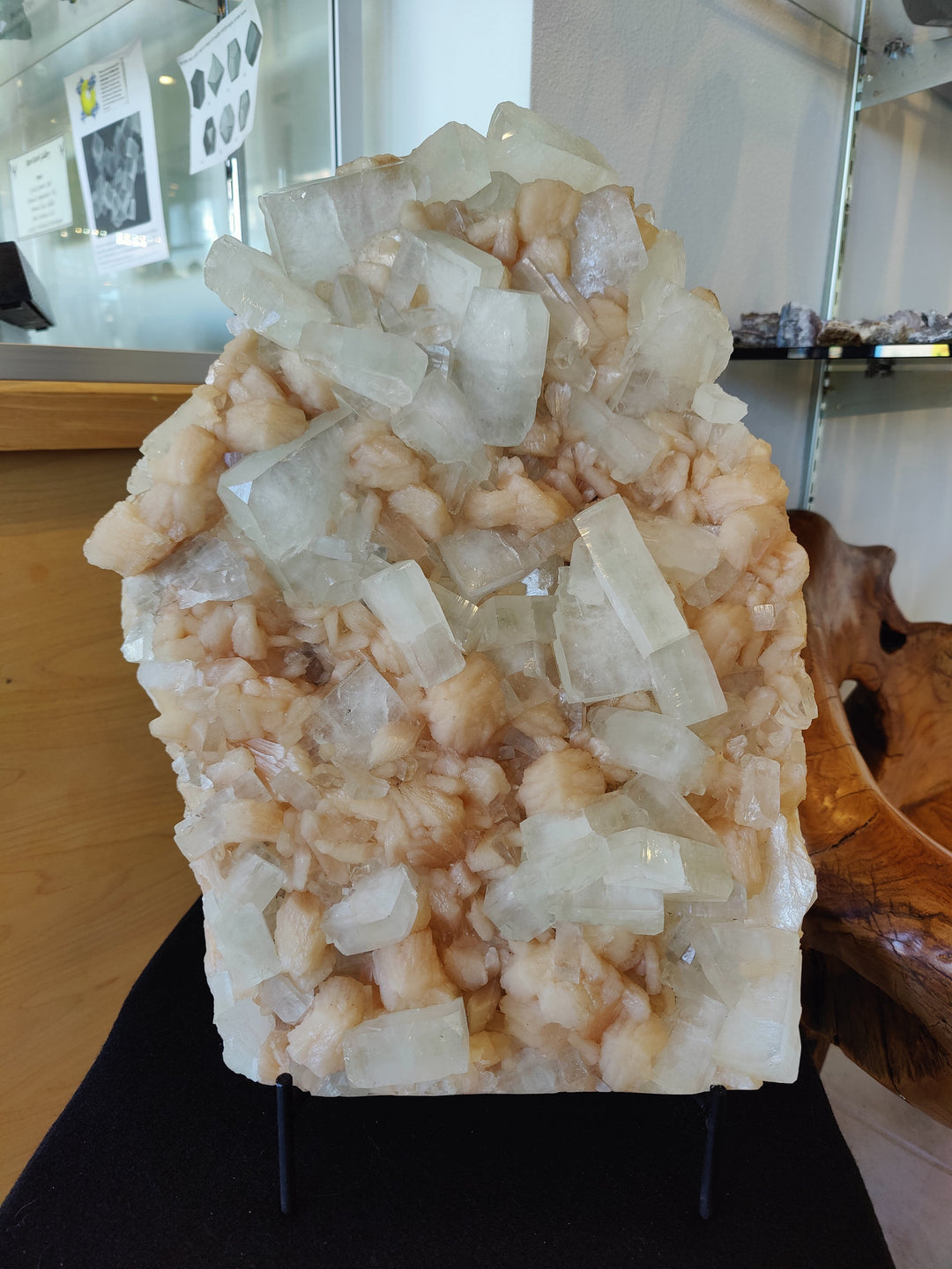 Clear and peach crystal specimen on black stand, clustered block crystals