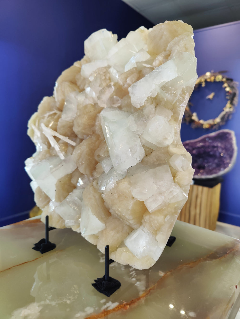 Crystal cluster specimen with clear white crystals and pale beige matrix on stand