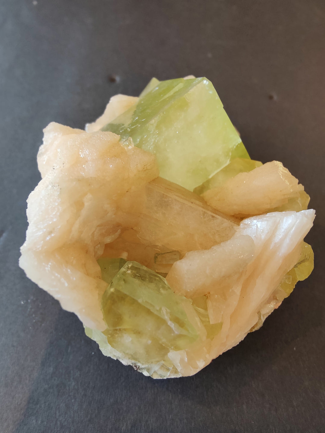 Green translucent cube crystals with cream-peach matrix, angled view