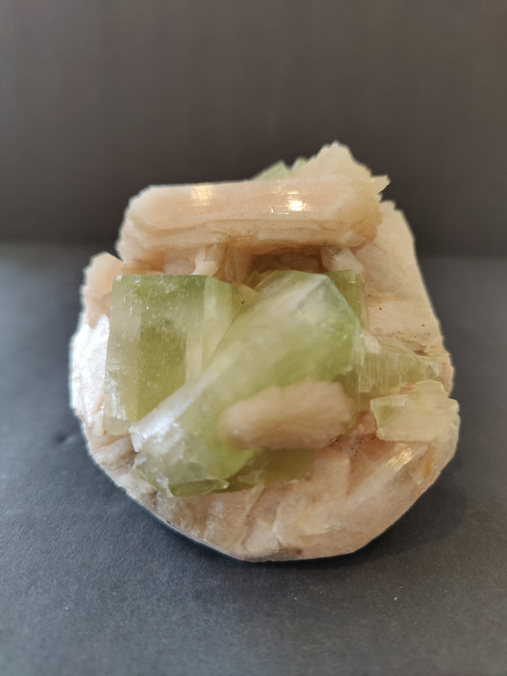 Green and peach mineral crystal specimen with translucent cube clusters
