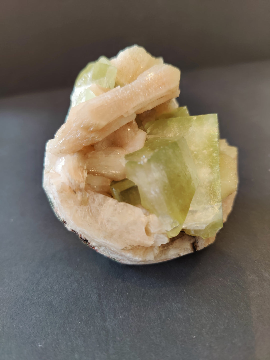 Peach and green mineral specimen with stacked translucent crystals