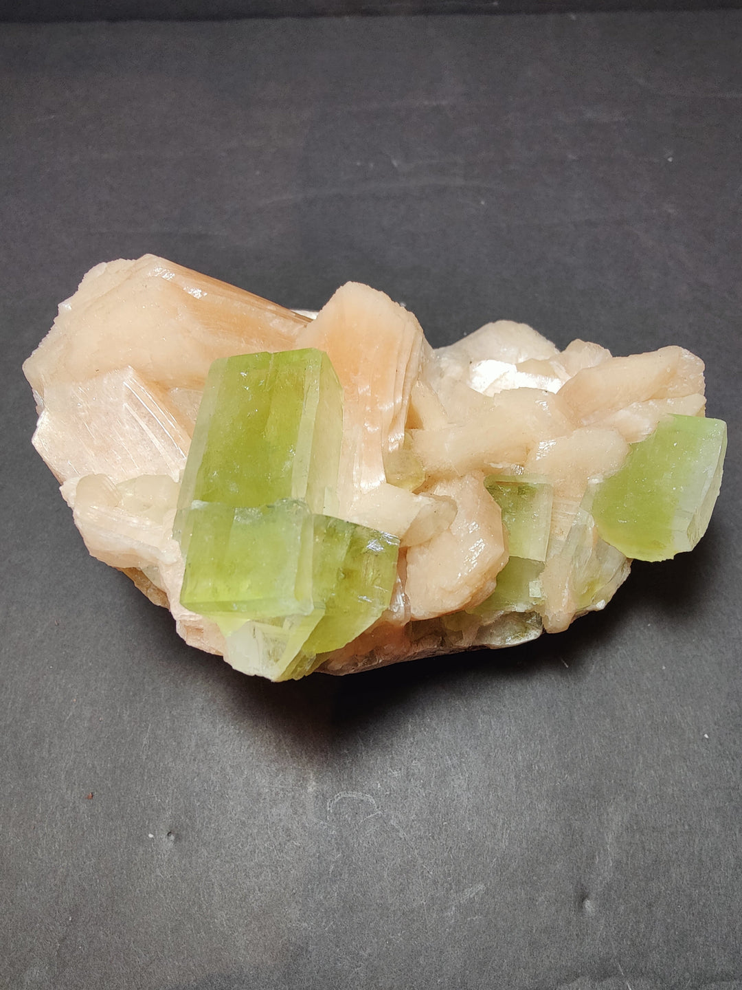 Peach-toned stilbite with bright green apophyllite rectangular crystals