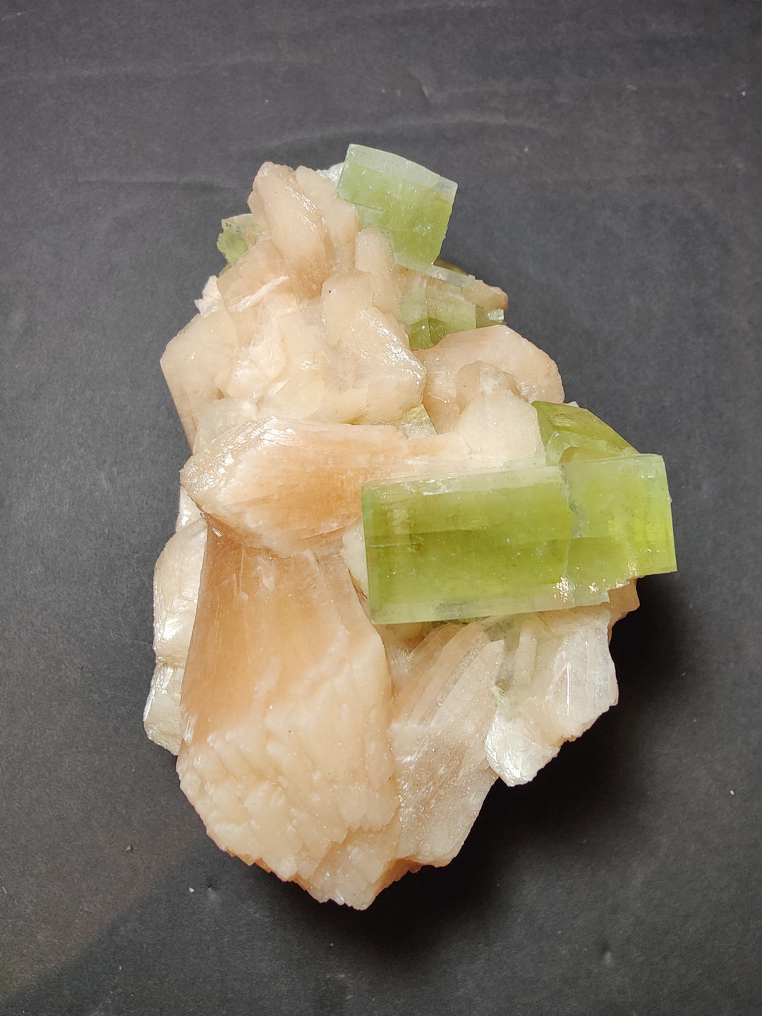 Green apophyllite cube cluster on peach stilbite mineral specimen