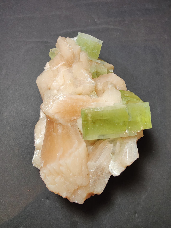 Green apophyllite cube cluster on peach stilbite mineral specimen