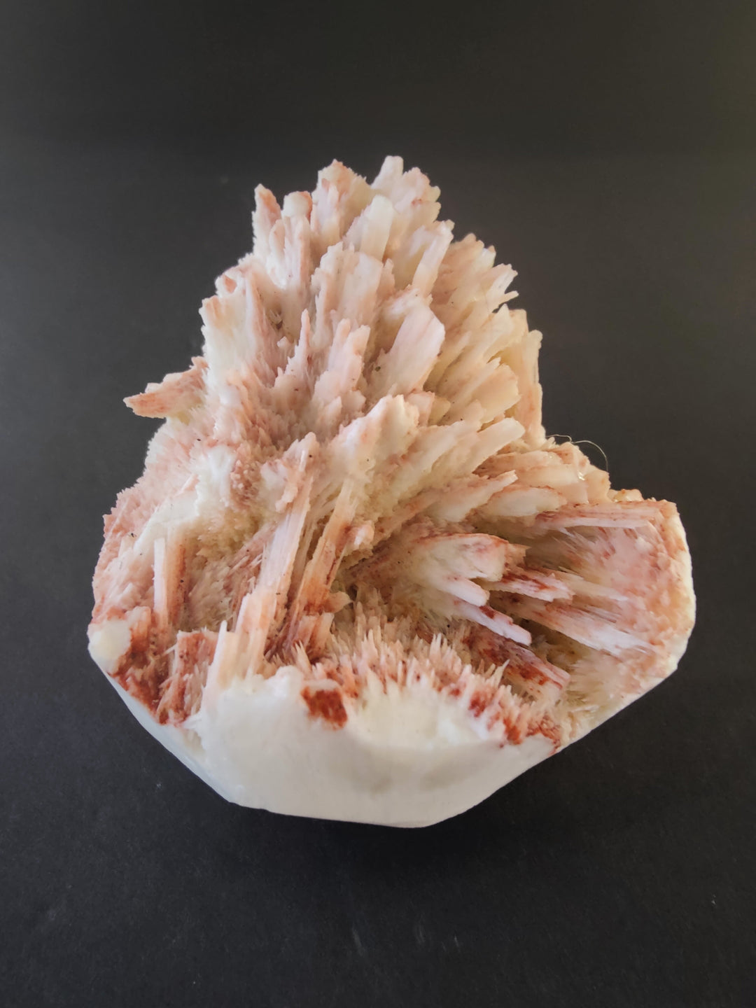 Mordenite and stilbite mineral specimen with peach crystal clusters on white base