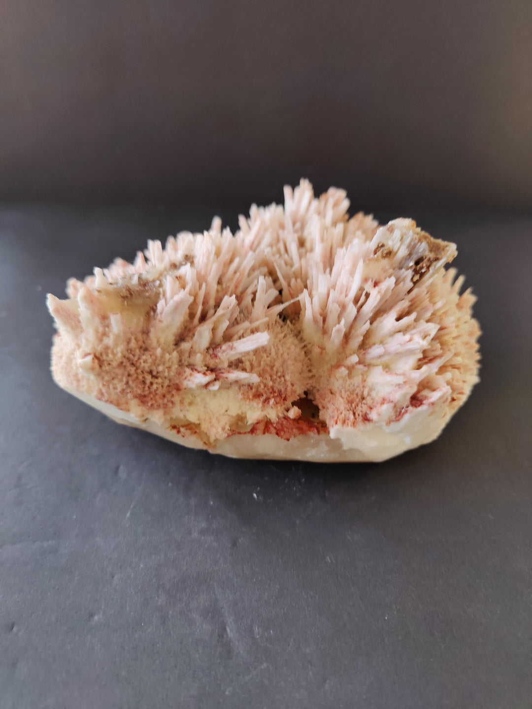 Red mordenite and stilbite crystal cluster on clear base, top view.