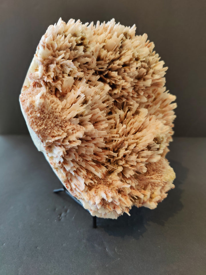 Mordenite-stilbite crystal cluster specimen on dark stand, tan fibrous sprays