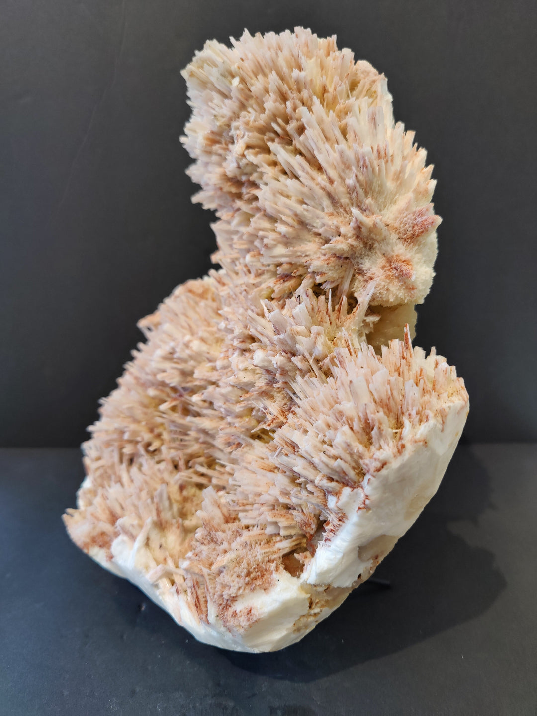 Mineral crystal specimen with pale peach needle clusters and cream base