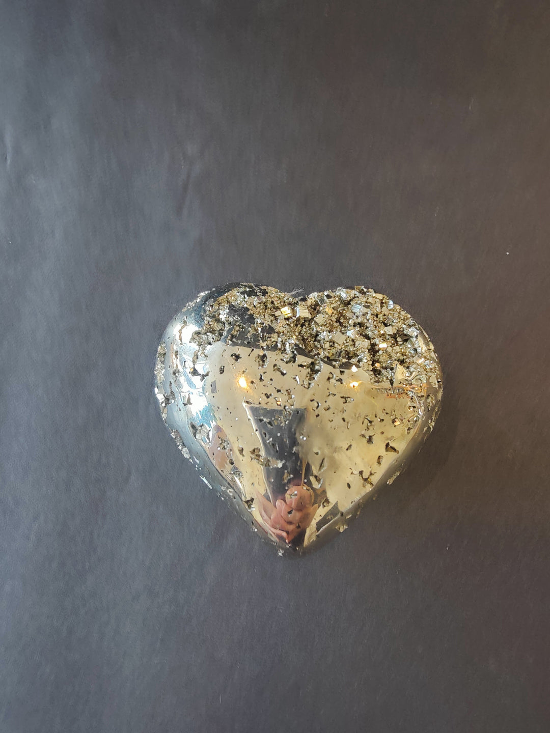 Heart-shaped polished pyrite gemstone with glittery gold flecks