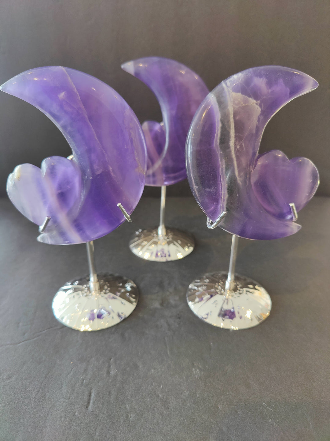 Purple fluorite half-moon and heart sculpture set on three 5 in metal stands