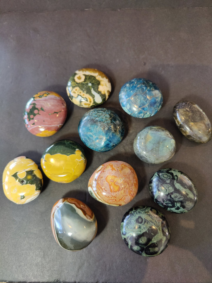 Polished palmstone stone set, round assorted stones with green, blue, and yellow patterns.