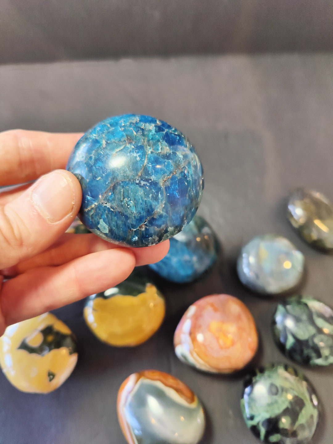 Polished blue palmstone with speckled texture; rounded oval stone.