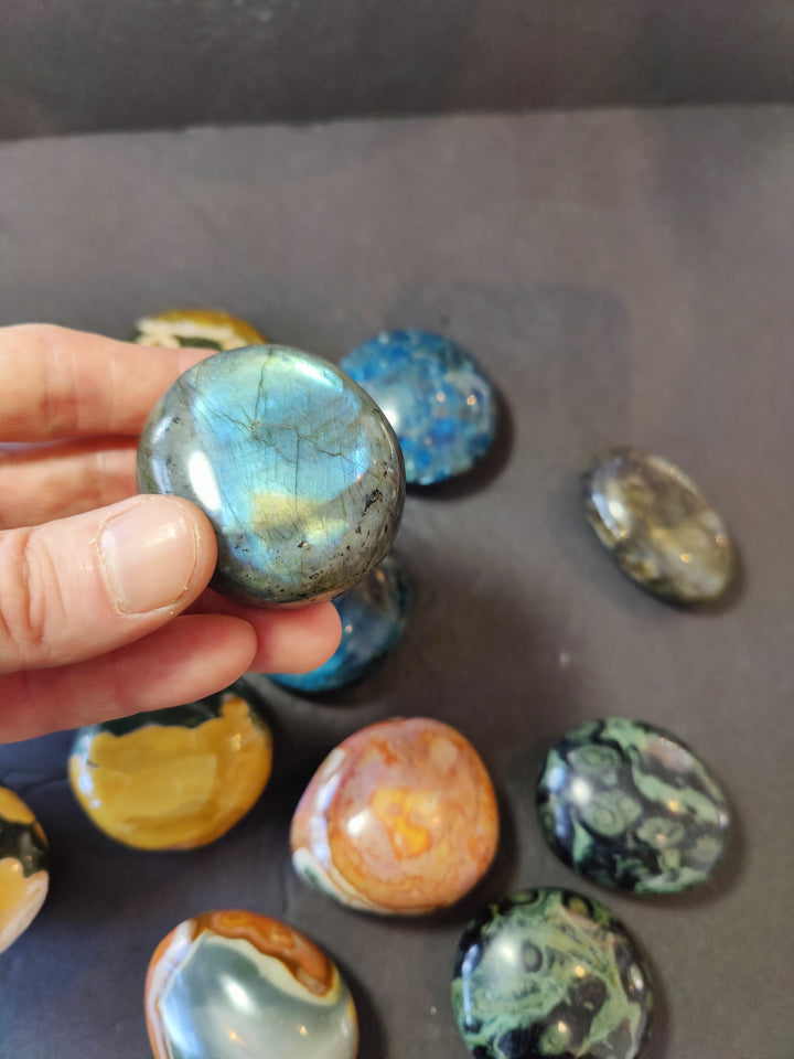 Polished light-blue palmstone with faint crackled lines; rounded oval stone.