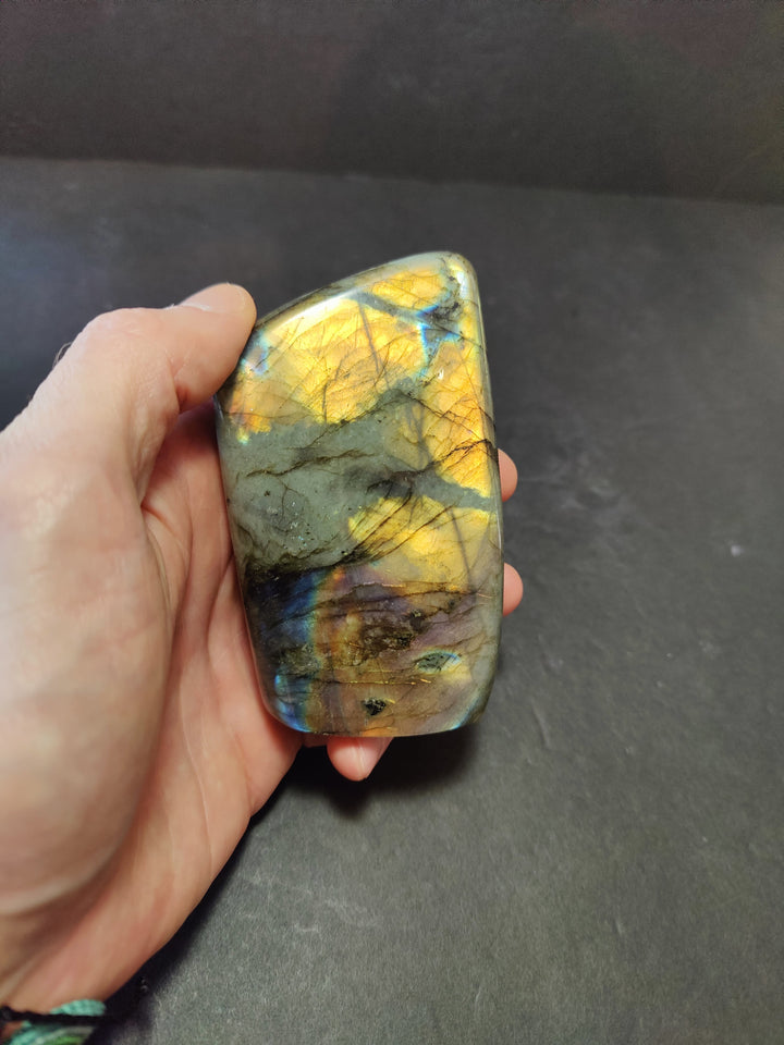 Polished labradorite freeform sculpture, pale gray with yellow gold and blue streaks