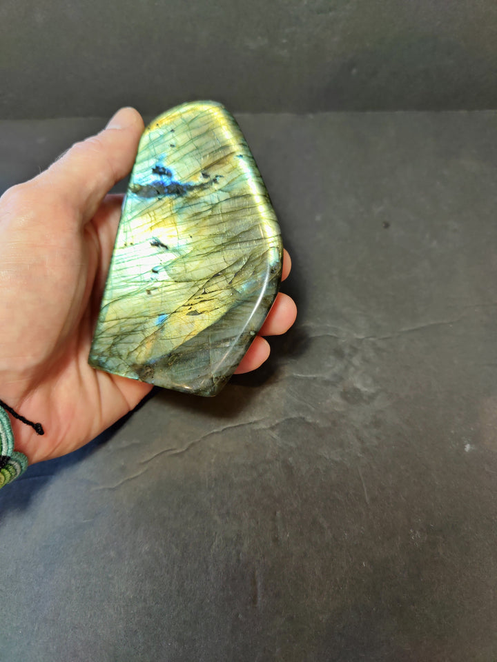 Polished labradorite freeform sculpture, aqua green with blue lines and bright gold flash