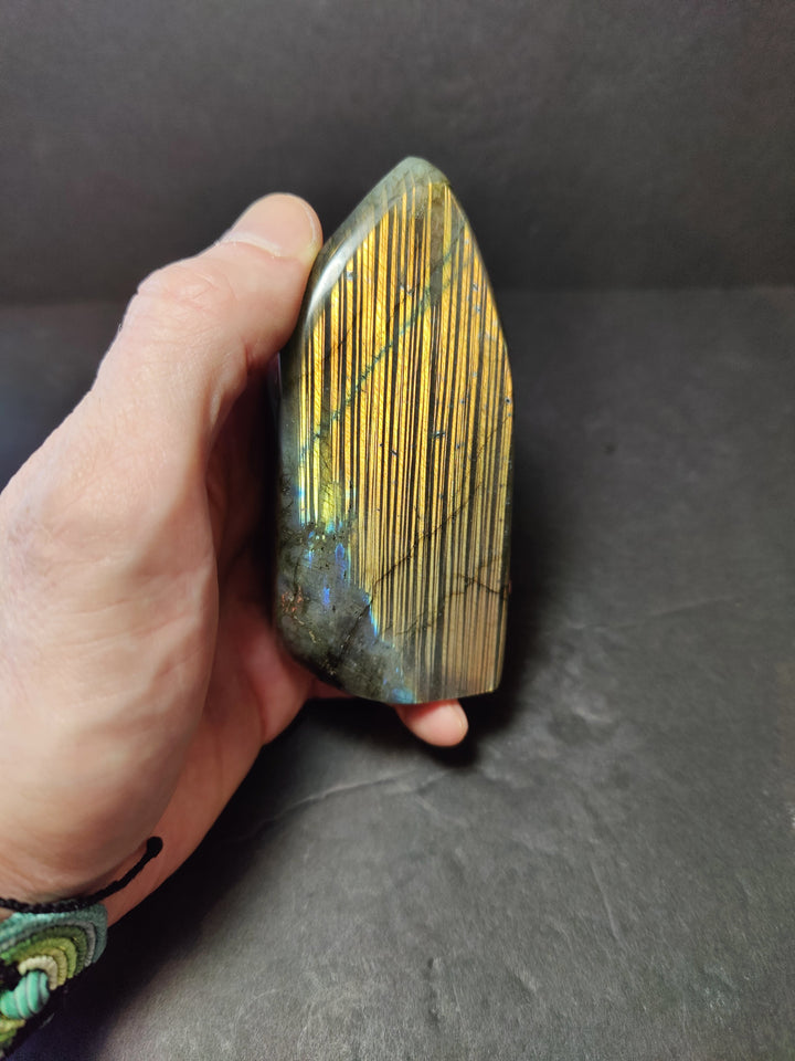 Polished labradorite freeform sculpture, tall oblong with gold stripes and blue accents